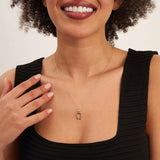 Mannequin souriant en haut noir portant un collier fer à cheval en or jaune 14 carats