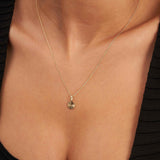 Collar de disco de sol radiante en oro amarillo de 14 quilates puesto en el cuello, vista cercana