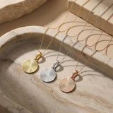 Collares de disco de sol radiante en oro amarillo, blanco y rosa de 14 quilates sobre travertino