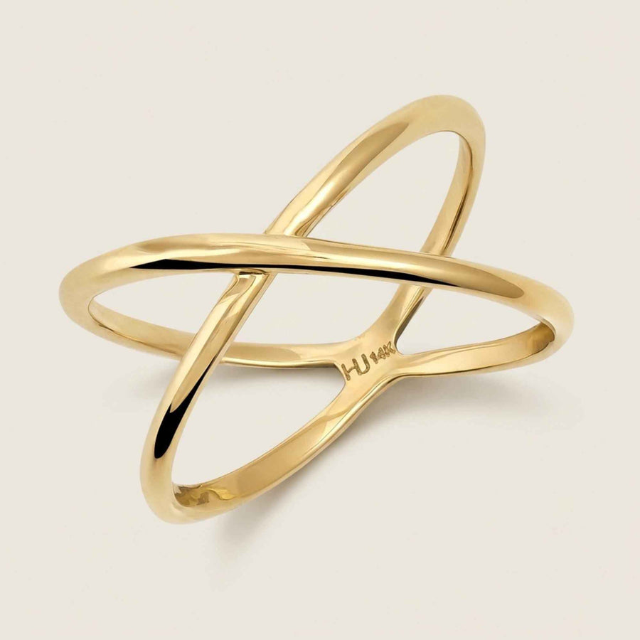 Bague infini entrecroisée en or jaune 14 carats en biais sur fond beige