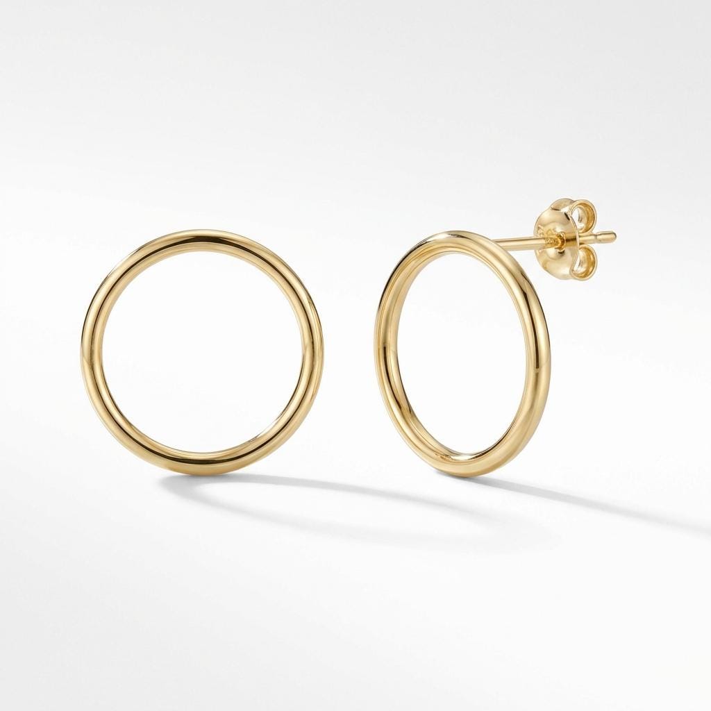 Paire de puces d'oreilles cercle en or jaune 14 carats sur fond gris doux