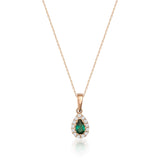 Collana halo in oro rosa 14kt con smeraldo taglio pera creato in laboratorio su sfondo bianco