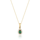 Collana halo in oro giallo 14kt con smeraldo taglio pera creato in laboratorio su sfondo bianco