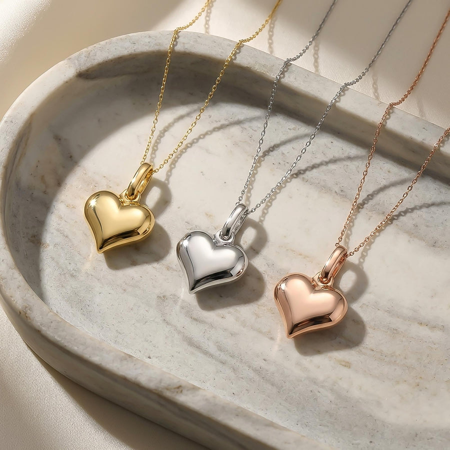 14K yellow, white and rose gold puffed heart necklaces in an oval stone dish