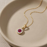 Collier halo rubis rond de synthèse en or jaune 14 carats enroulé dans une coupelle en céramique