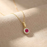 Pendentif halo rubis rond de synthèse en or jaune 14 carats drapé sur du lin, gros plan