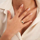 Swirl-Kuppelring aus 585er Gelbgold an einer Hand, die auf der Brust ruht