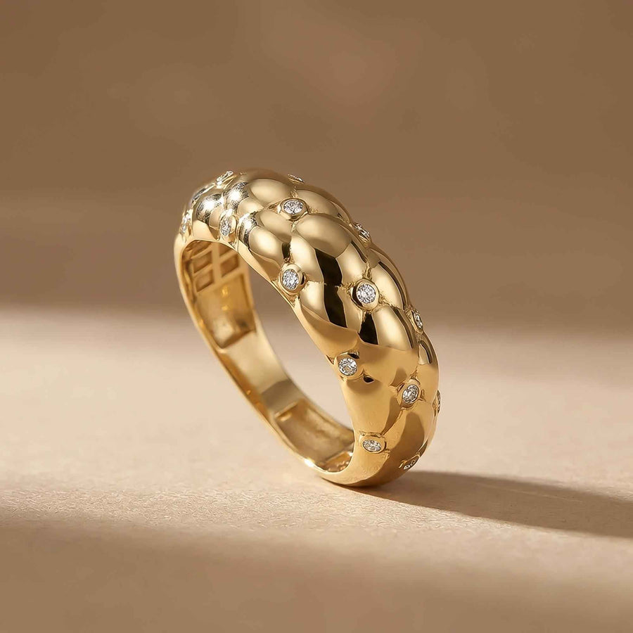Bubble-Kuppelring mit Zirkonia aus 585er Gelbgold, stehend vor beigem Hintergrund