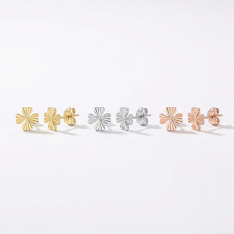 Puces d'oreilles trèfle à quatre feuilles en or jaune, blanc et rose 14 carats alignées sur fond blanc