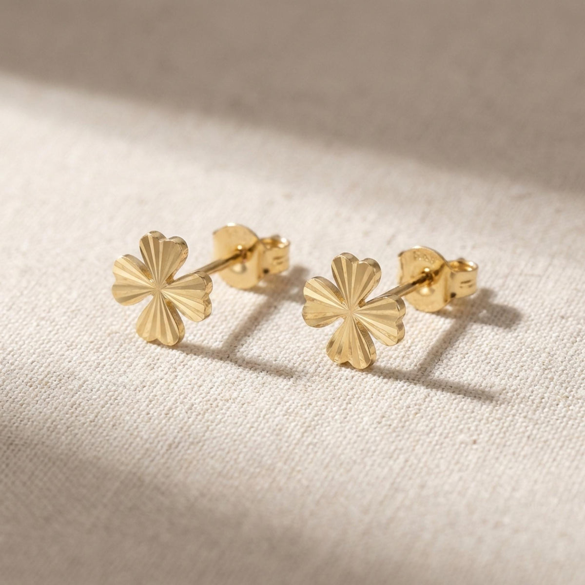 Par de pendientes de botón de trébol diamantados en oro amarillo de 14 quilates sobre lino natural