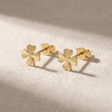 Par de pendientes de botón de trébol diamantados en oro amarillo de 14 quilates sobre lino natural
