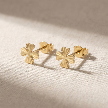 Paire de puces d'oreilles trèfle taille diamant en or jaune 14 carats sur du lin naturel