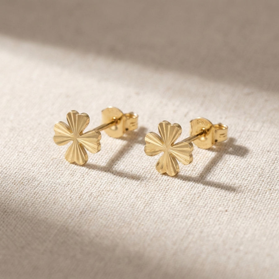 Par de pendientes de botón de trébol diamantados en oro amarillo de 14 quilates sobre lino natural
