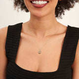 Mannequin souriant en haut noir portant un collier empreinte de patte en or jaune 14 carats