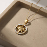 14K yellow gold compass star pendant with CZ ring in a stone dish