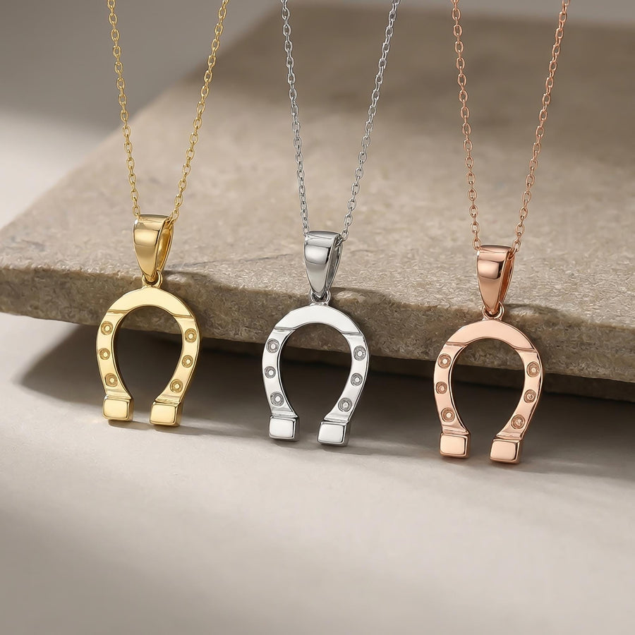 Pendentifs fer à cheval en or jaune, blanc et rose 14 carats suspendus à un rebord en pierre