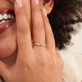 Close-up of 14K yellow gold CZ band ring on finger near model's smile