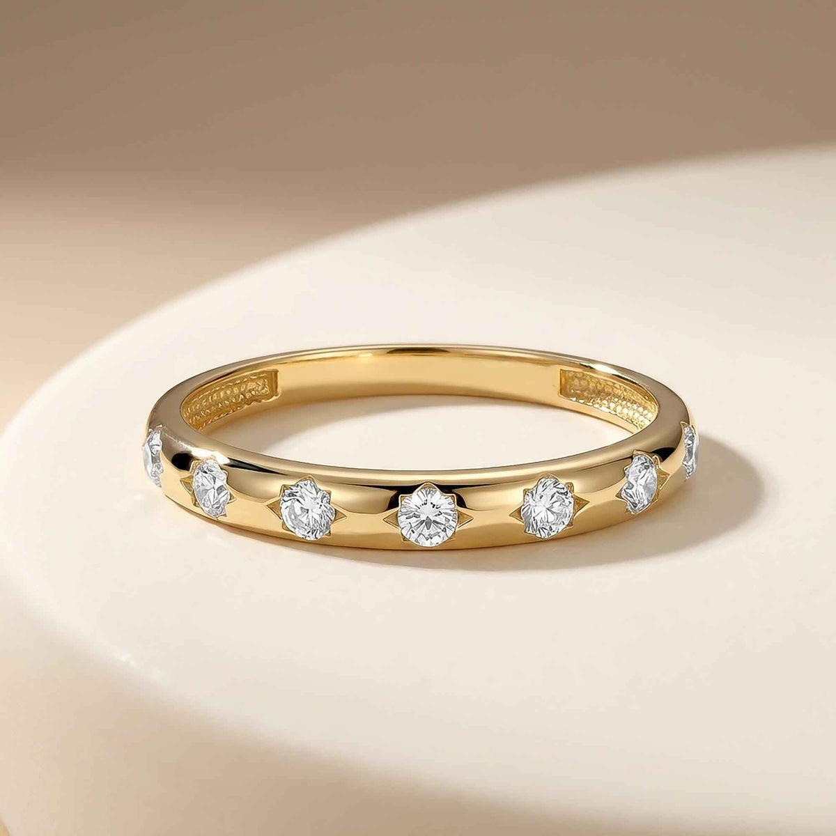 14K yellow gold CZ band ring on a white plate