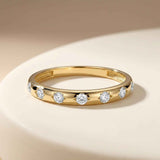 14K yellow gold CZ band ring on a white plate