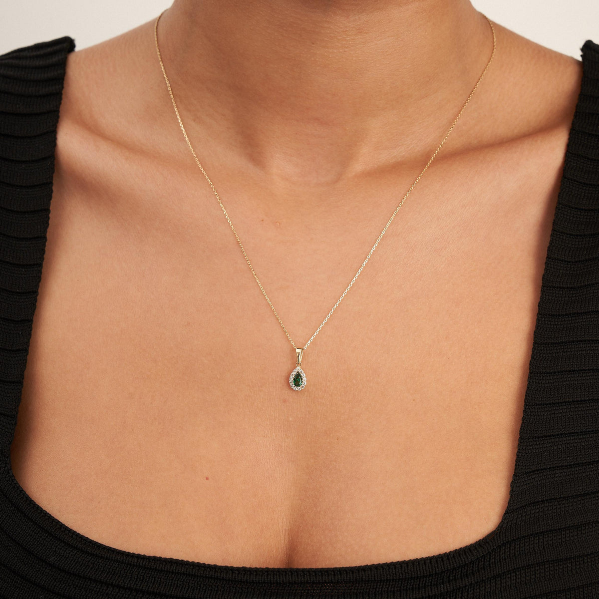 Collana halo in oro giallo 14kt con smeraldo taglio pera creato in laboratorio indossata dalla modella, vista frontale