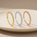 Anillos burbuja en oro amarillo, blanco y rosa de 14 quilates en vertical sobre un plato blanco