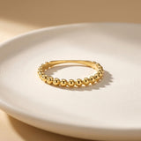 Anillo burbuja en oro amarillo de 14 quilates sobre un plato blanco