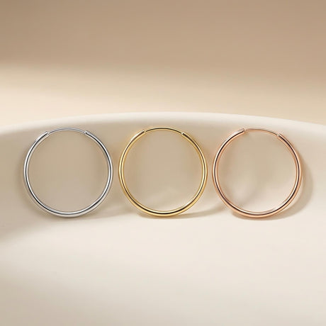 Créoles sans fin en or blanc, jaune et rose 14 carats dans une coupelle en céramique