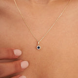 Collier halo saphir rond de synthèse en or jaune 14 carats posé sur la clavicule
