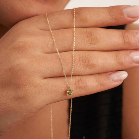 Main du mannequin tenant un collier solitaire citrine en or jaune 14 carats