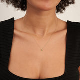 Collar solitario de citrino en oro amarillo de 14 quilates llevado por la modelo con top negro