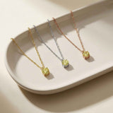 Collares solitarios de citrino en oro amarillo, blanco y rosa de 14 quilates en una bandeja de cerámica