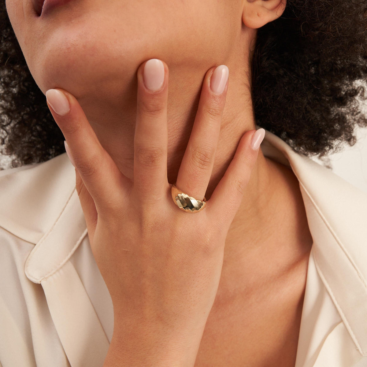 Swirl-Kuppelring aus 585er Gelbgold an der Hand unter dem Kinn des Models