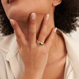 Swirl-Kuppelring aus 585er Gelbgold an der Hand unter dem Kinn des Models