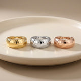 Diamantierte Kuppelringe aus 585er Gelbgold, Weißgold und Roségold auf einem weißen Teller