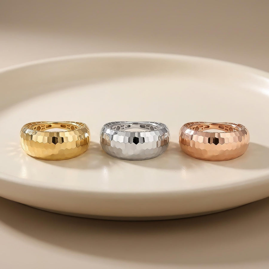 Diamantierte Kuppelringe aus 585er Gelbgold, Weißgold und Roségold auf einem weißen Teller