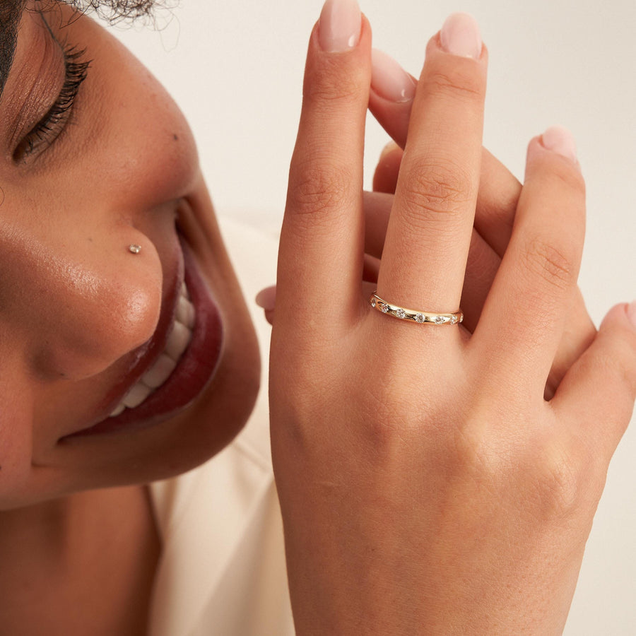 14K yellow gold CZ band ring on model's raised hand