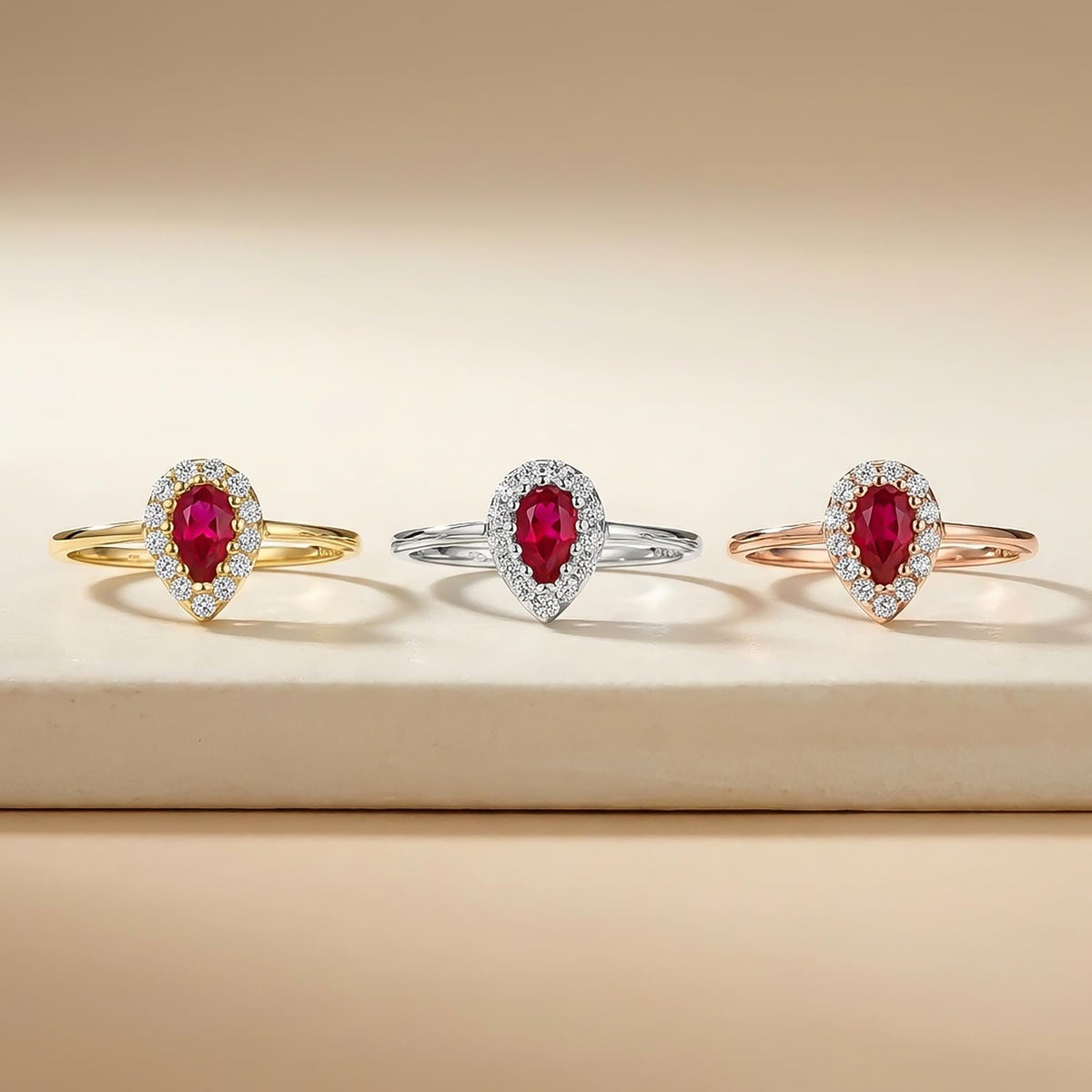 Lab-grown ruby pear halo rings in 14K yellow, white and rose gold