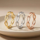 Bagues infini ajourées en or jaune, blanc et rose 14 carats posées debout sur une assiette blanche