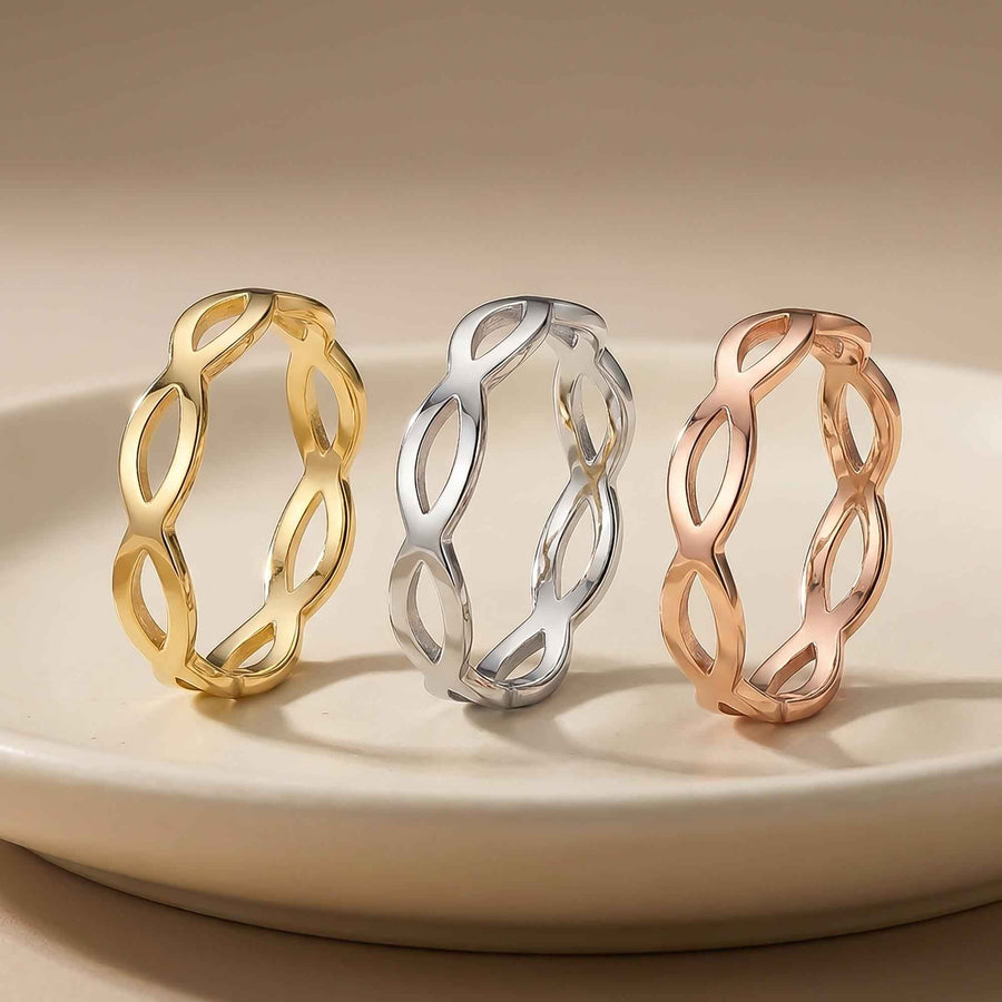 Bagues infini ajourées en or jaune, blanc et rose 14 carats posées debout sur une assiette blanche