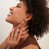 Mannequin de profil, regard vers le haut, portant des puces d'oreilles fleur en oxyde de zirconium et or jaune 14 carats