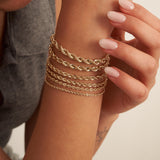 Polso con bracciali a catena a corda in oro giallo 14kt sovrapposti, da 2,15 mm a 5 mm