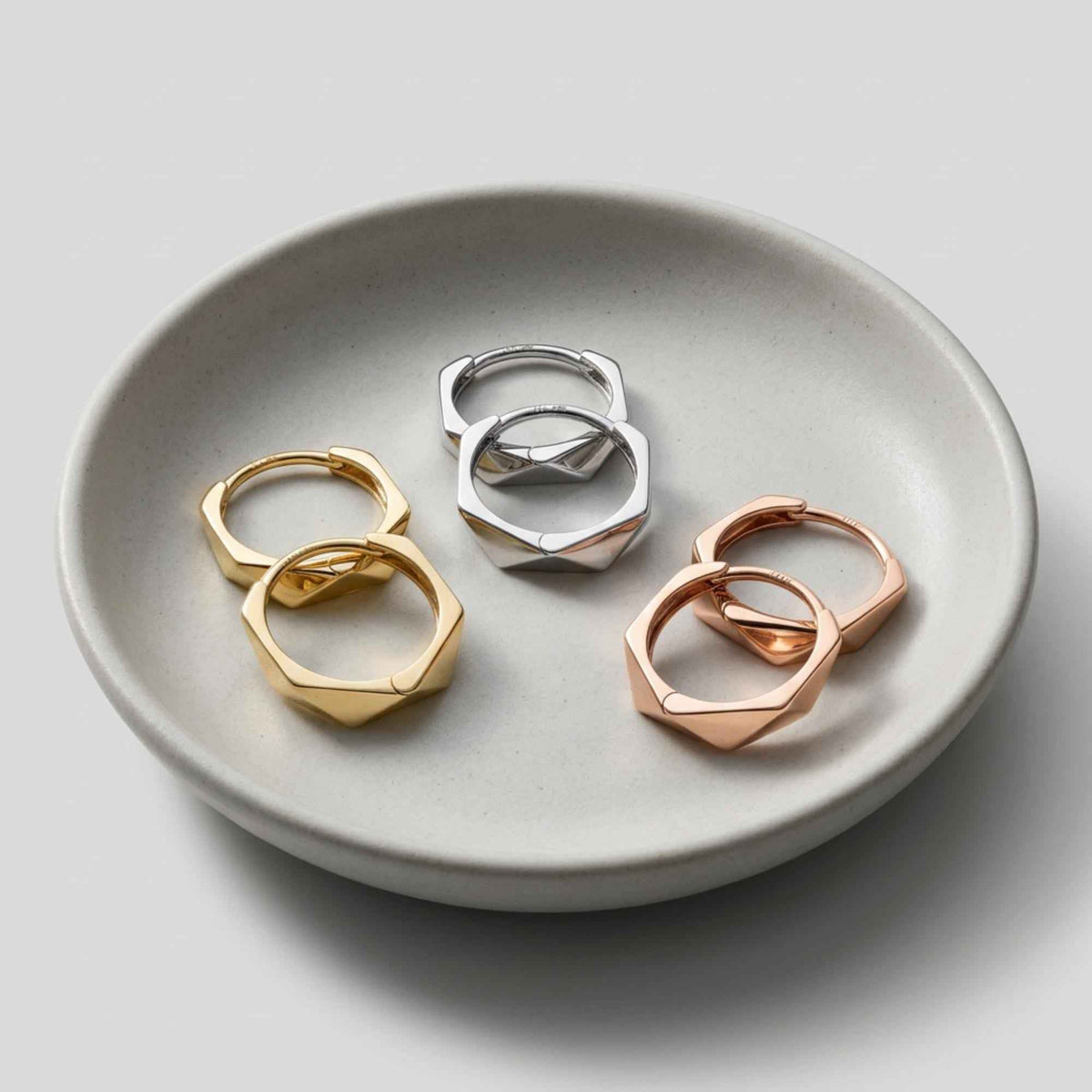 Créoles hexagonales facettées en or jaune, blanc et rose 14 carats dans une coupelle en céramique