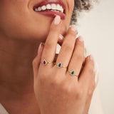 Smiling model with 14K yellow gold pear halo rings on her fingers