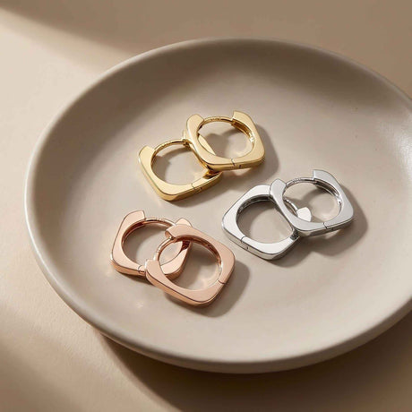 Créoles carrées en or jaune, blanc et rose 14 carats sur une assiette en céramique