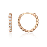 Créoles à oxydes de zirconium en serti clos en or rose 14 carats, vue de côté et de face sur fond blanc