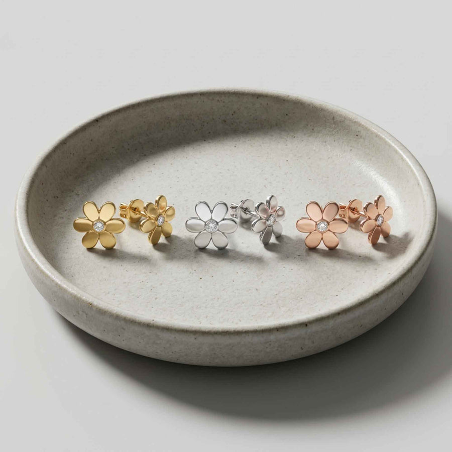 Puces d'oreilles fleur marguerite en or jaune, blanc et rose 14 carats dans une coupelle en céramique