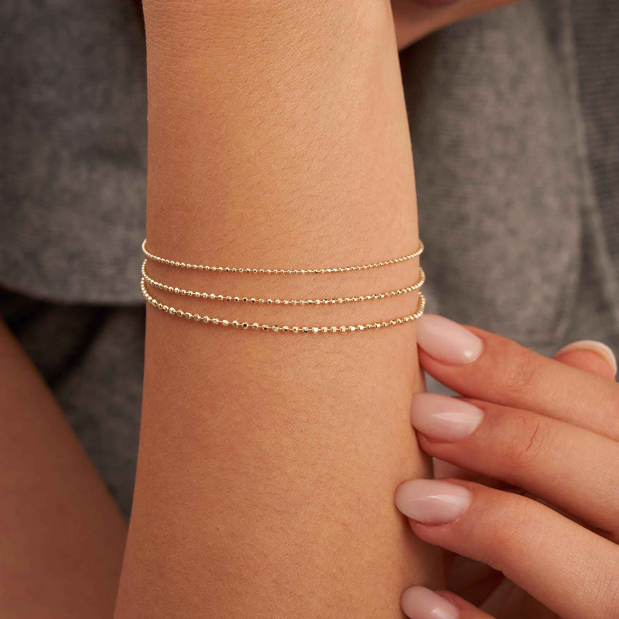 Pulseras de cadena de bolitas en oro amarillo de 14 quilates con tres tamaños de bolita en la muñeca